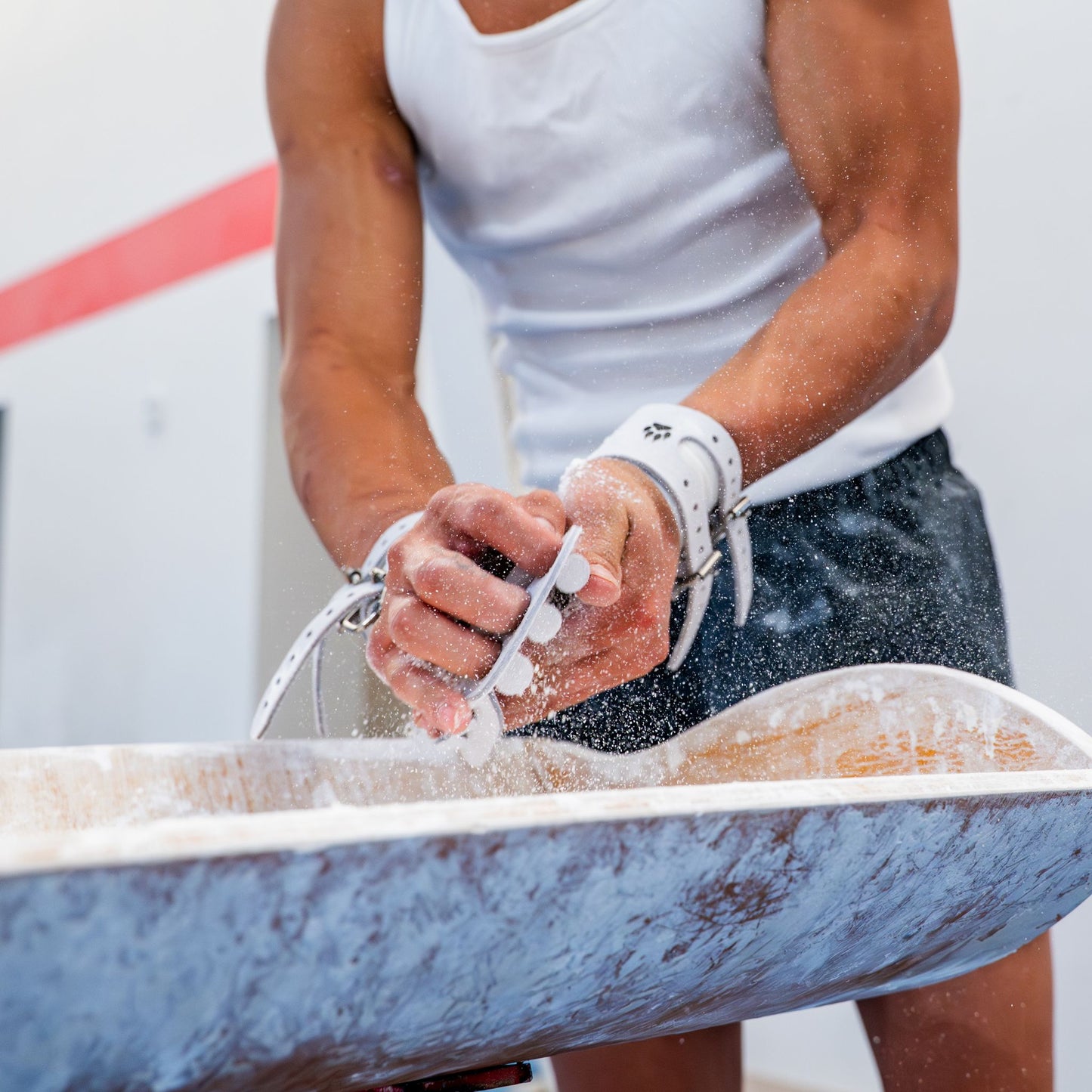 Yul Moldauer chalking up at the chalk bowl wearing his Wolf Wear signature grip