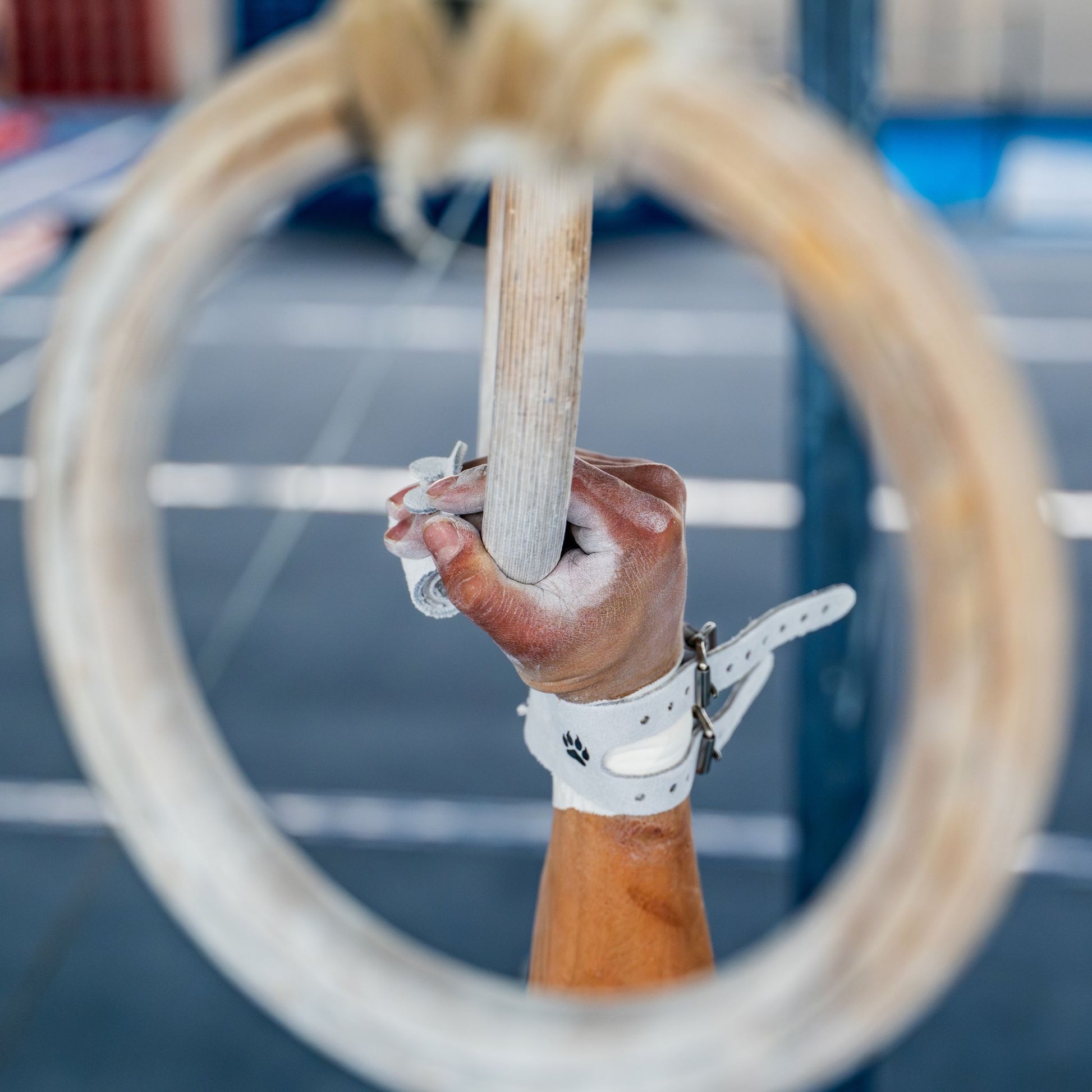 Close-up of Yul Moldauer Wolf Wear ring grip on the rings, showing leather and Wolf Wear paw logo